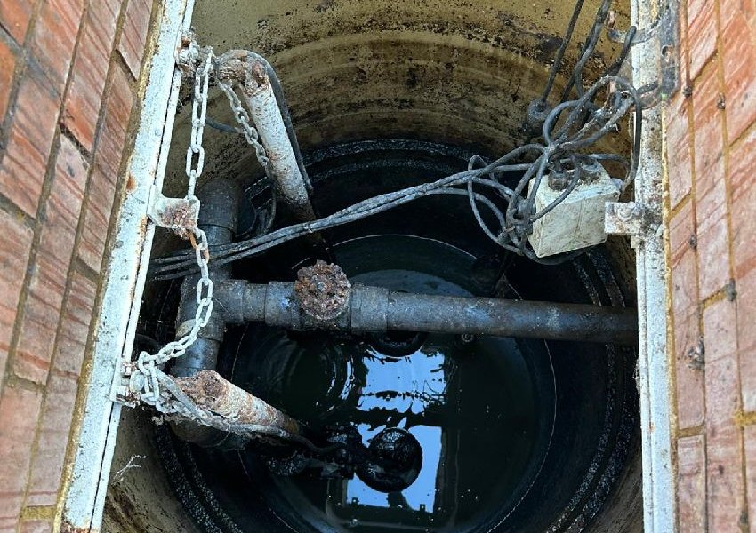 Pump chamber seen from above with lifting chains and a junction box on the wall