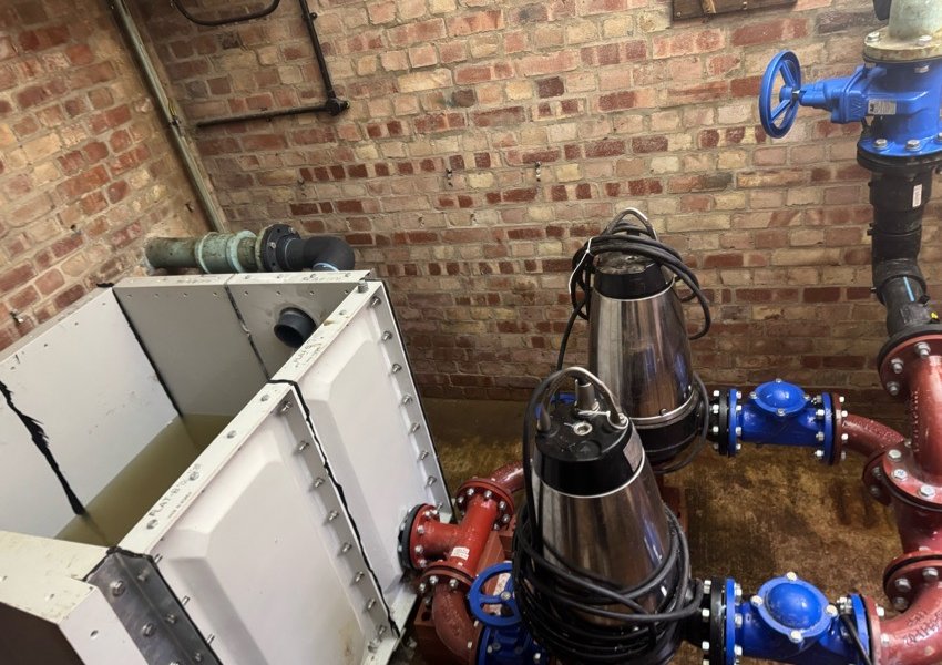 Two new submersible pumps with red bends and blue valves in a new pump chamber in Havant
