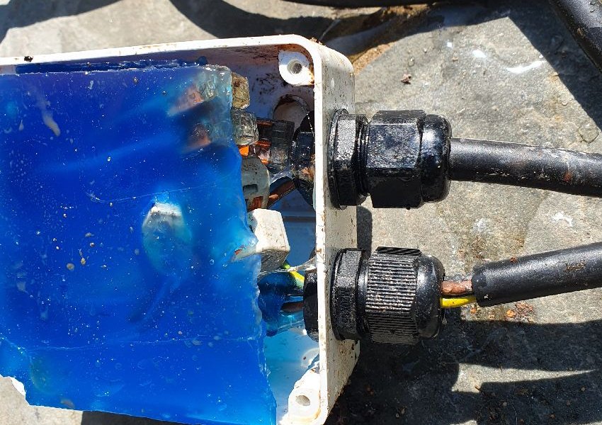 Junction box filled with blue sealing gel on pump cables near Send