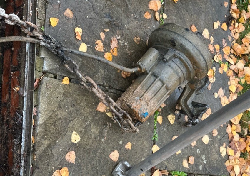 Submersible pump lifted out of a chamber on its lifting chain