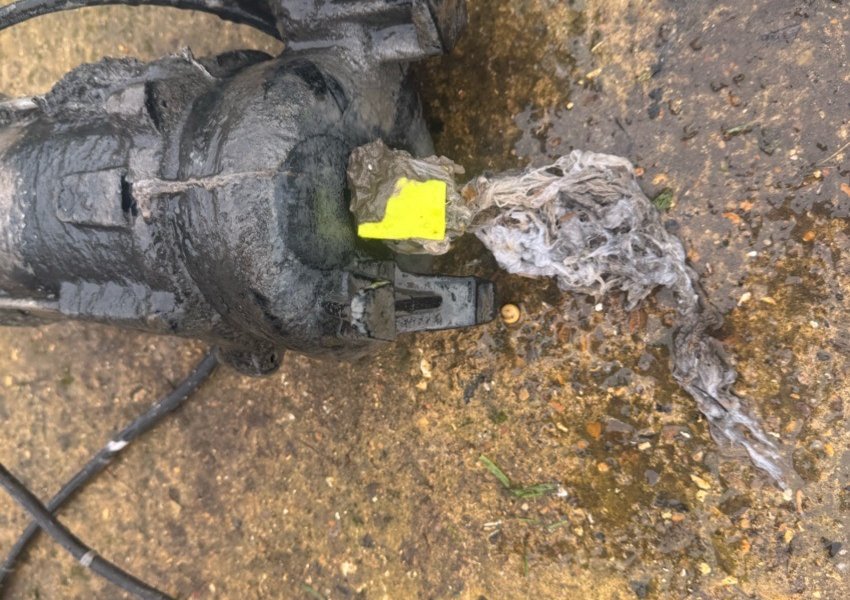 Pump with rag and wipes wrapped around it after being lifted from a chamber near Woking