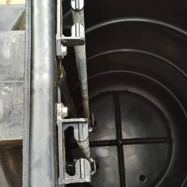Close-up of metal guide rails inside a black pump chamber