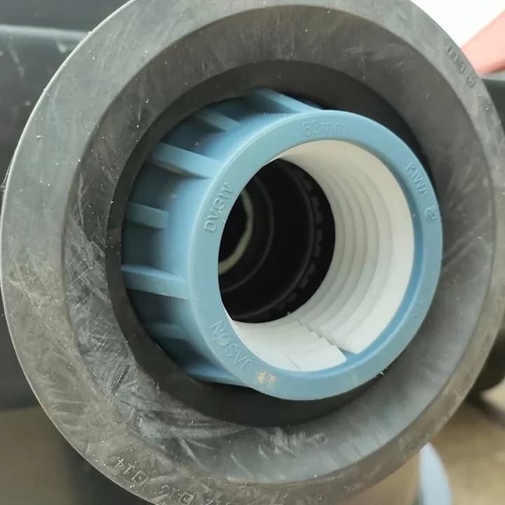 Blue KIWA branded pipe connector fitted into the chamber wall