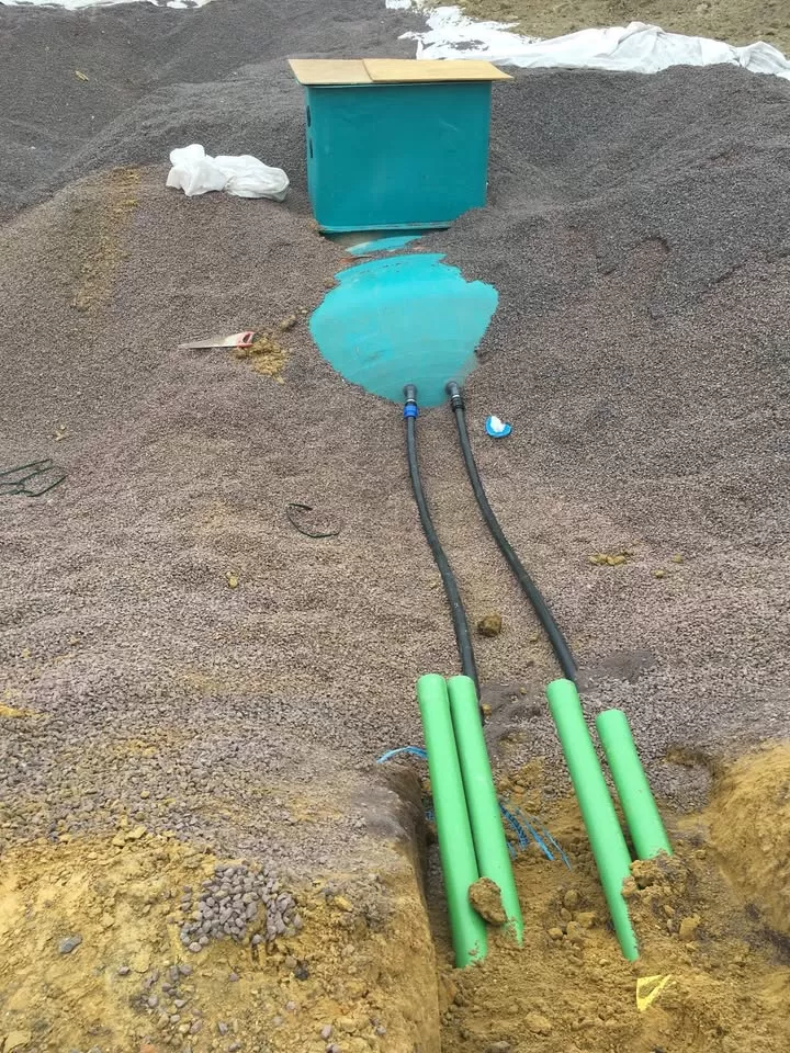 Underground rainwater tank being positioned in a gravel bed at a construction site